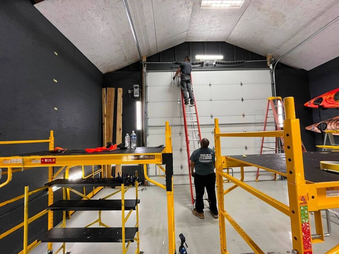 We Fix Garage Doors technicians performing maintenance on a tall commercial overhead door