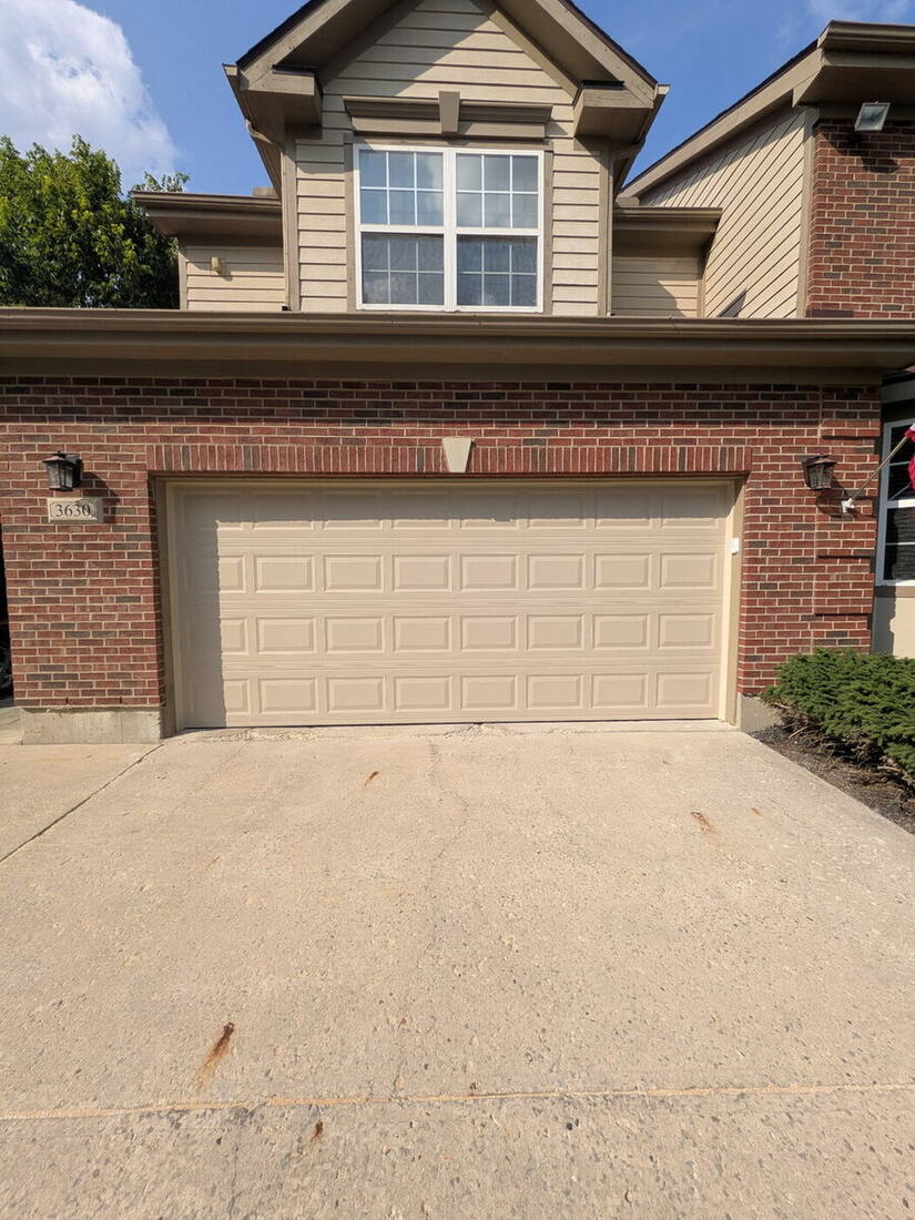 Clean tan garage door working perfectly after repair