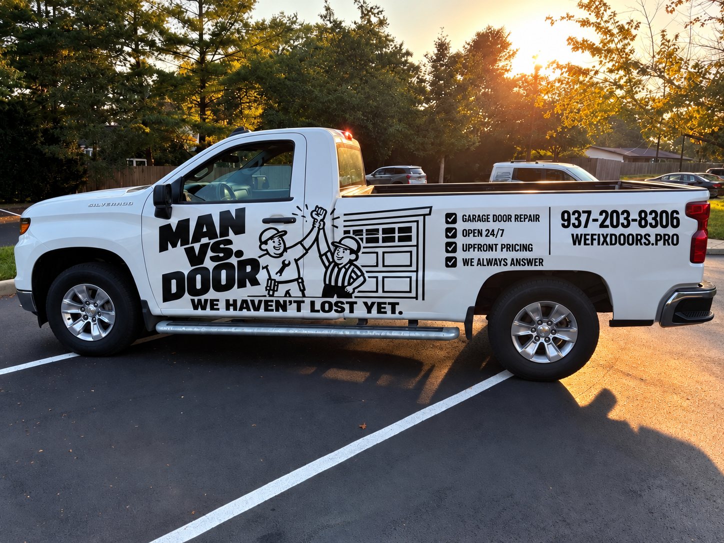 MAN VS DOOR service truck in a Dayton driveway — (937) 203-8306, wefixdoors.pro