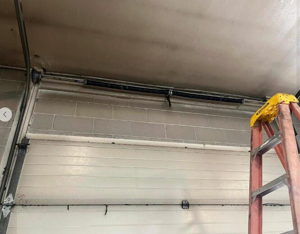 Technician servicing a large commercial garage door