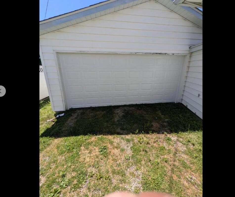 Weathered residential garage door before replacement in Springfield