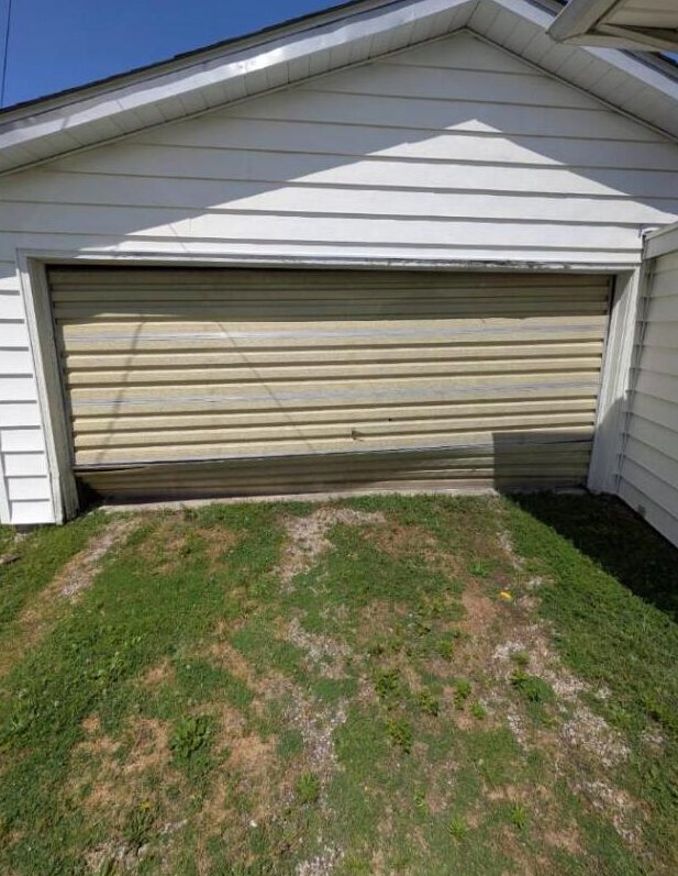 Bent roll-up door before repair