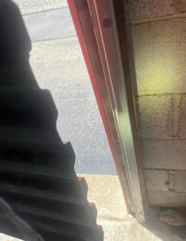 Close-up of damaged garage door hardware needing cable repair